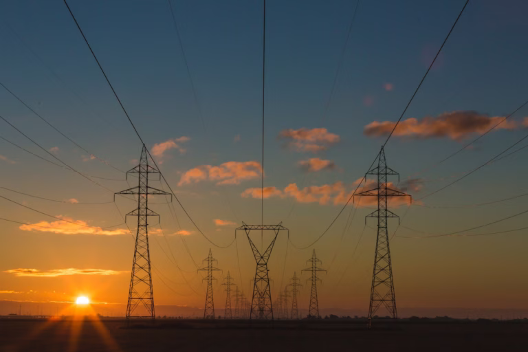 mercado livre de energia: torres de transmissão ao entardecer